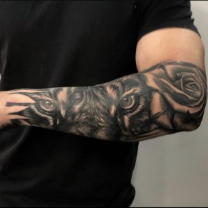 Half sleeve tattoo with tiger eyes and rose